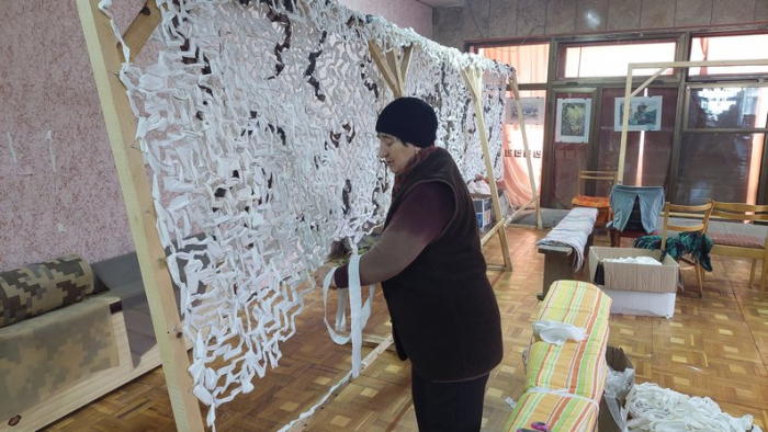 В Ужгороді вимушені переселенці та містяни плетуть маскувальні сітки для військових